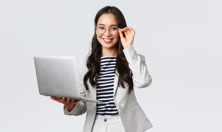 Factoring: mulher-de-negocios-asiatica-sorridente-usa-terno-branco-oculos-e-segura-computador